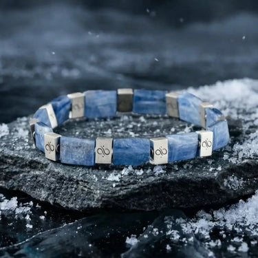Blue bracelet with silver accents on a dark, snowy background